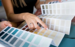 Interior designer consulting a client on wall paint samples, as they discuss the perfect house renovation color scheme. Psychology of Paint Colors in Interior Design