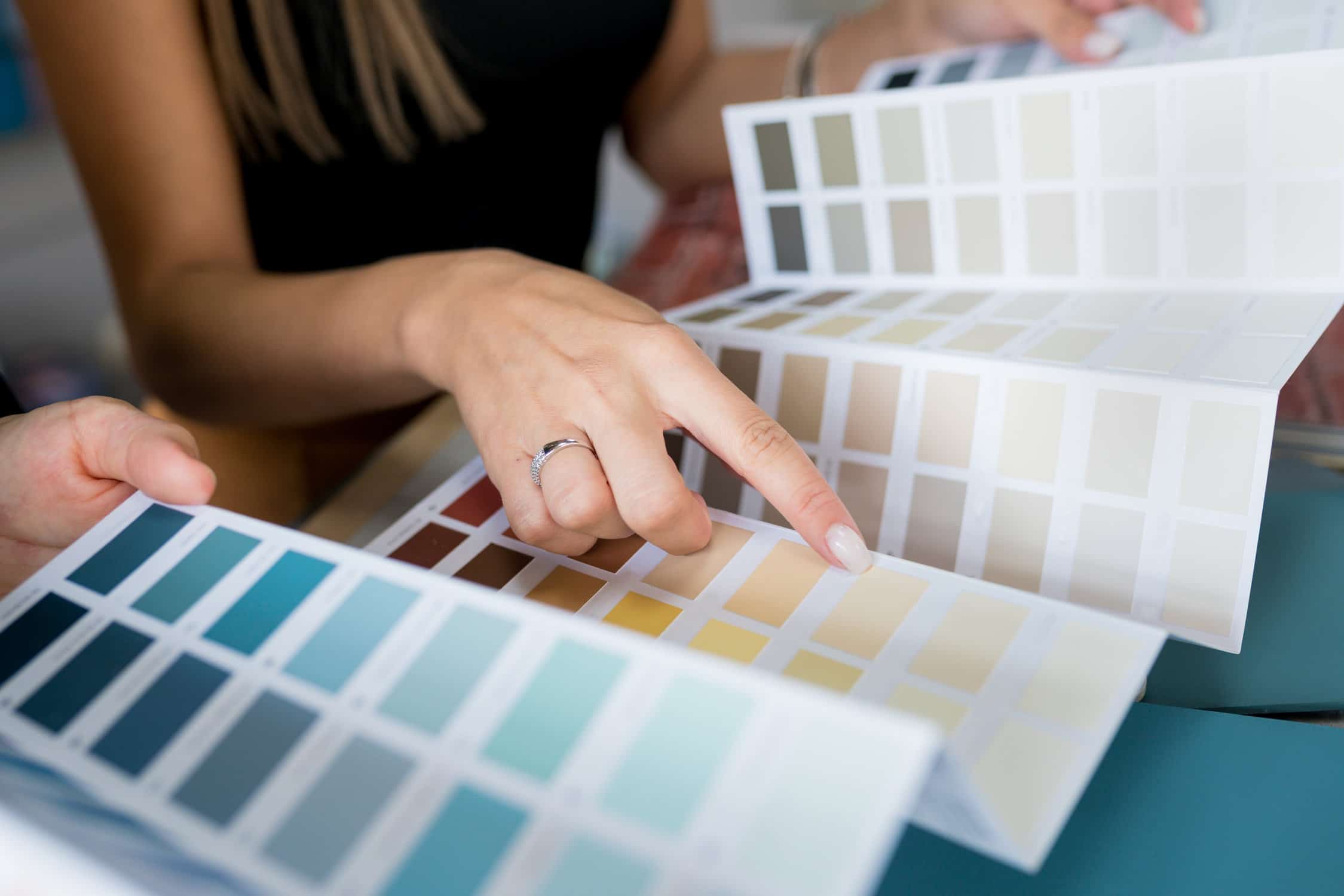 Interior designer consulting a client on wall paint samples, as they discuss the perfect house renovation color scheme. Psychology of Paint Colors in Interior Design