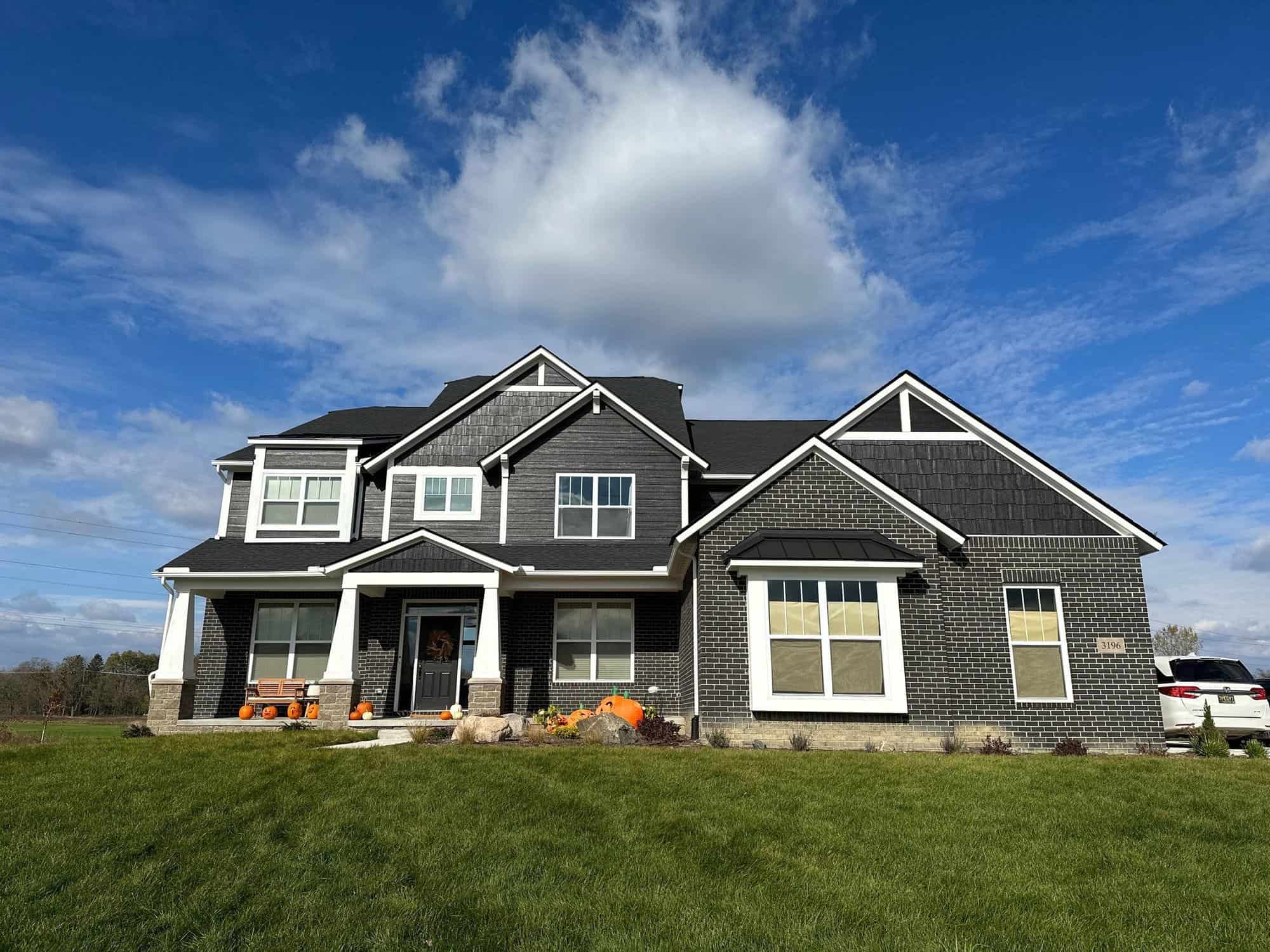 Front view of the black house. It is surrounded by grass.exterior painting safety