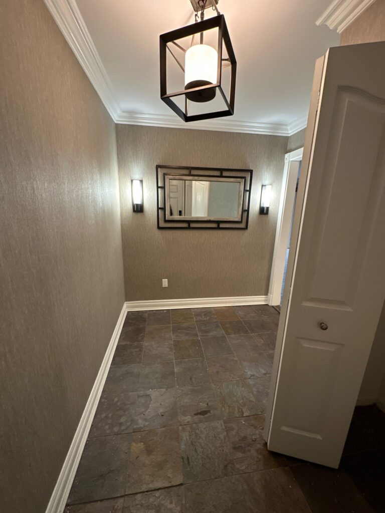 Olive walls and brown wooden floors with white trims and door.