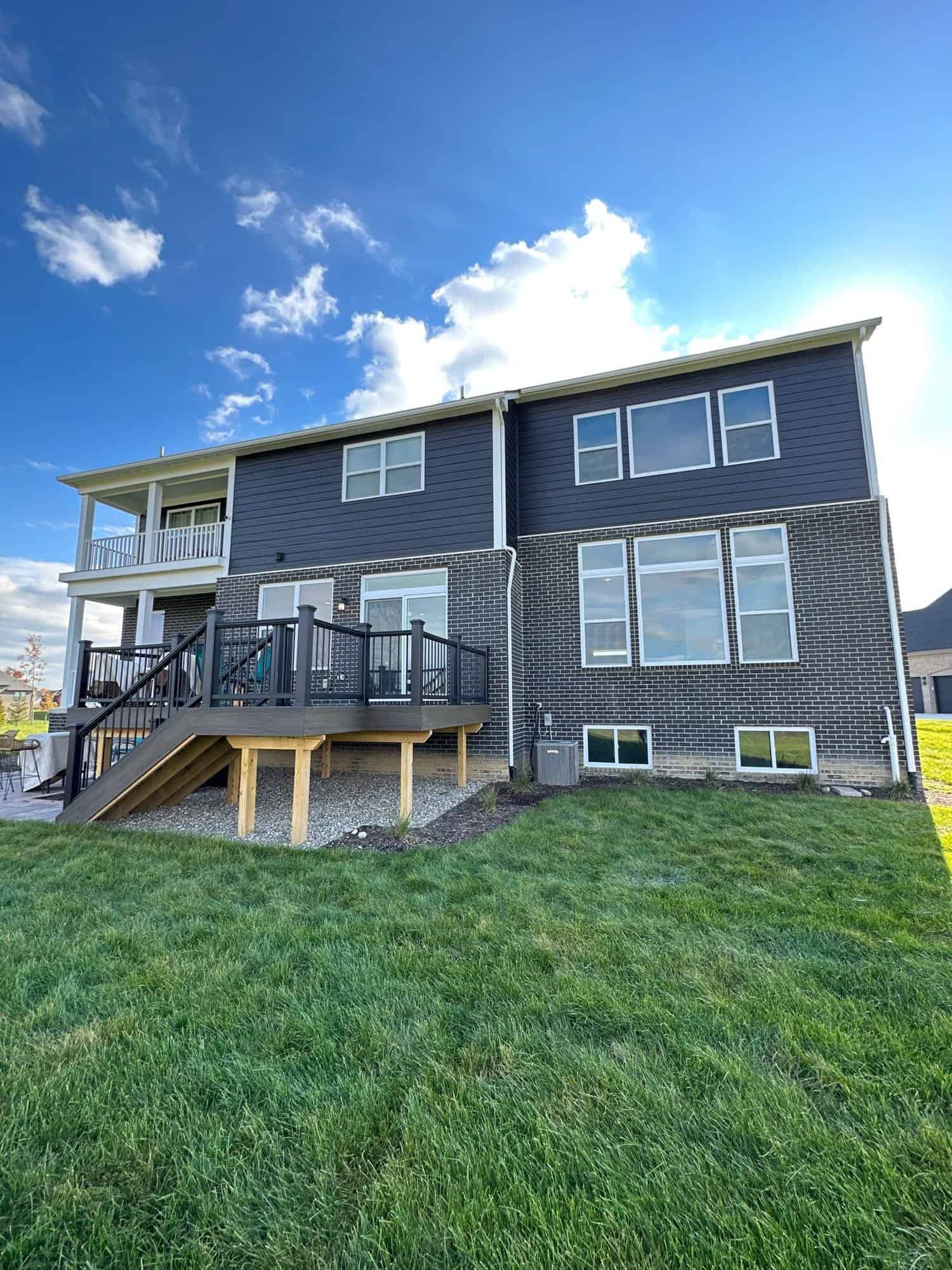 Side view showing the wooden deck, balcony and patio of the black house.