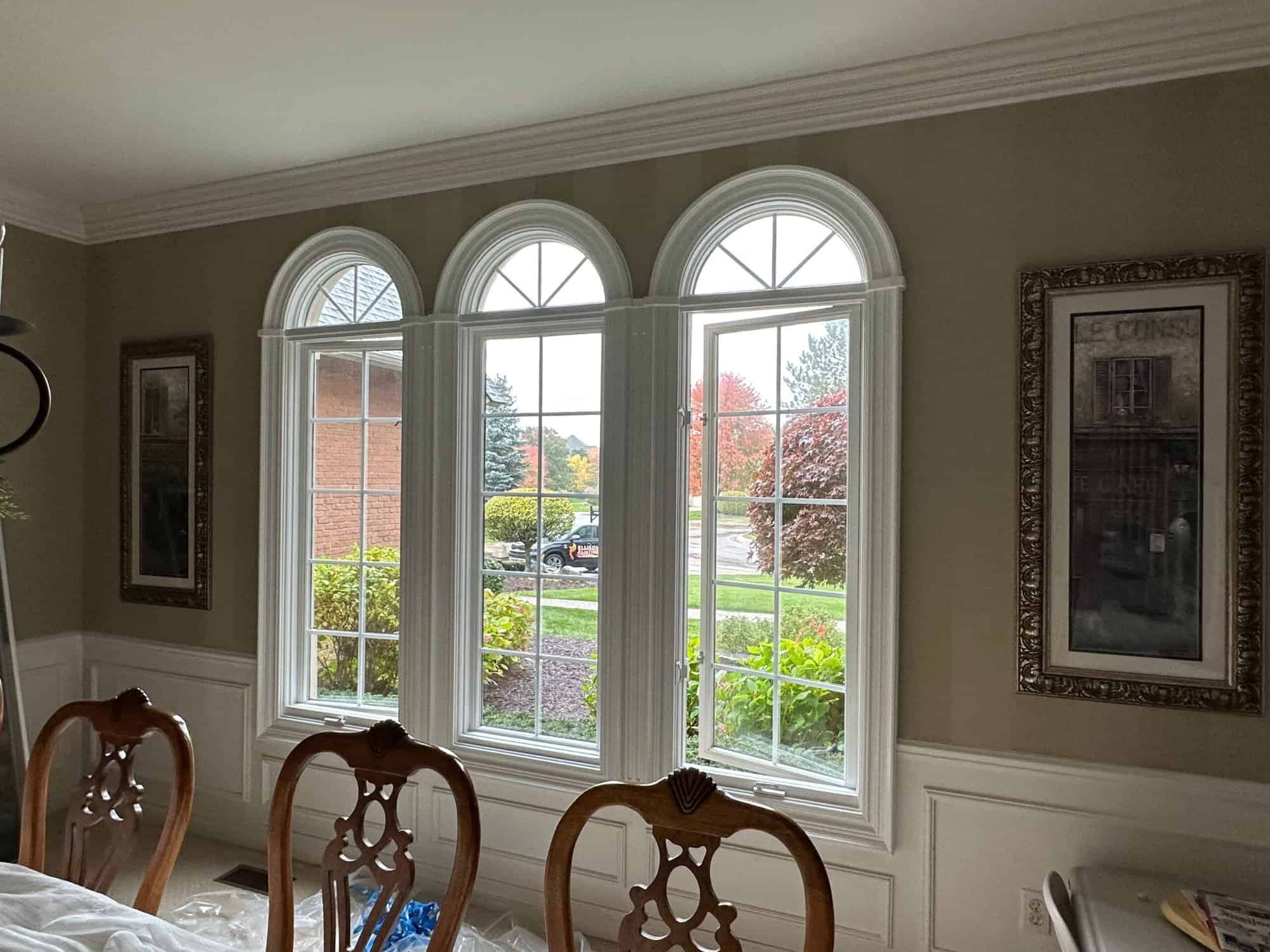 Three large windows in the dining room with white trims.