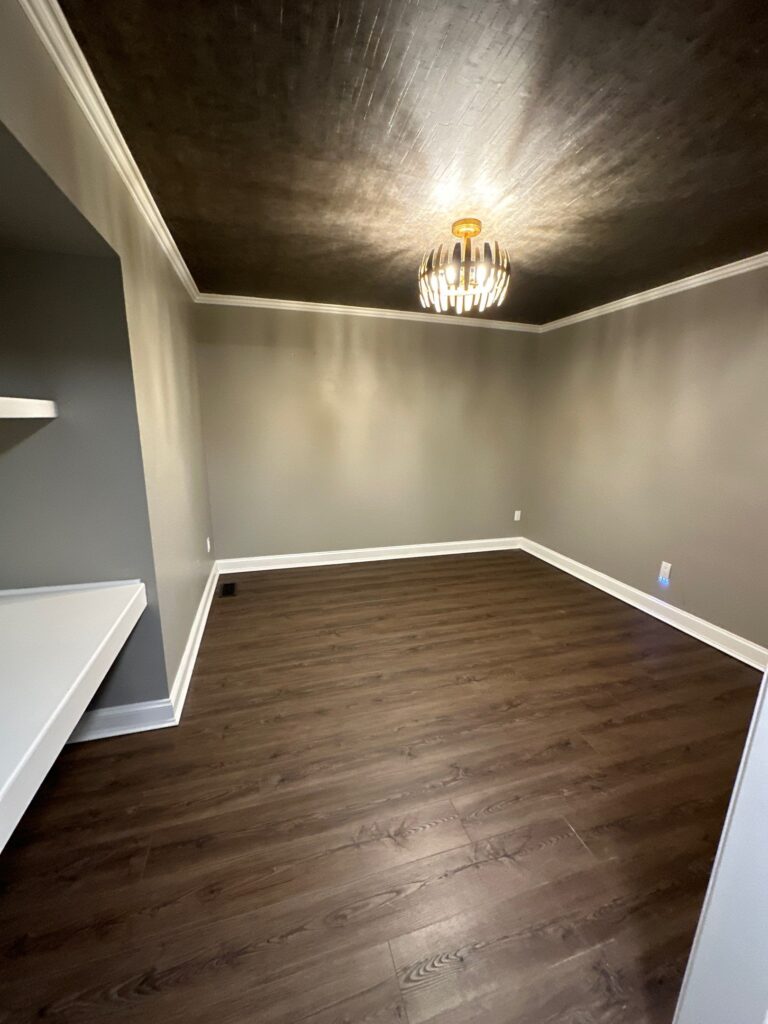 Gray walls, brown ceiling, and wooden floors.